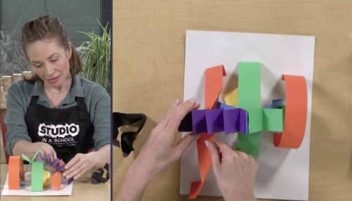 colored paper being constructed by a teacher upon a desk