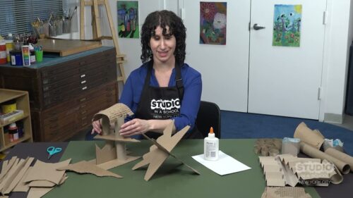 Teacher with cardboard structure on the table in front of them