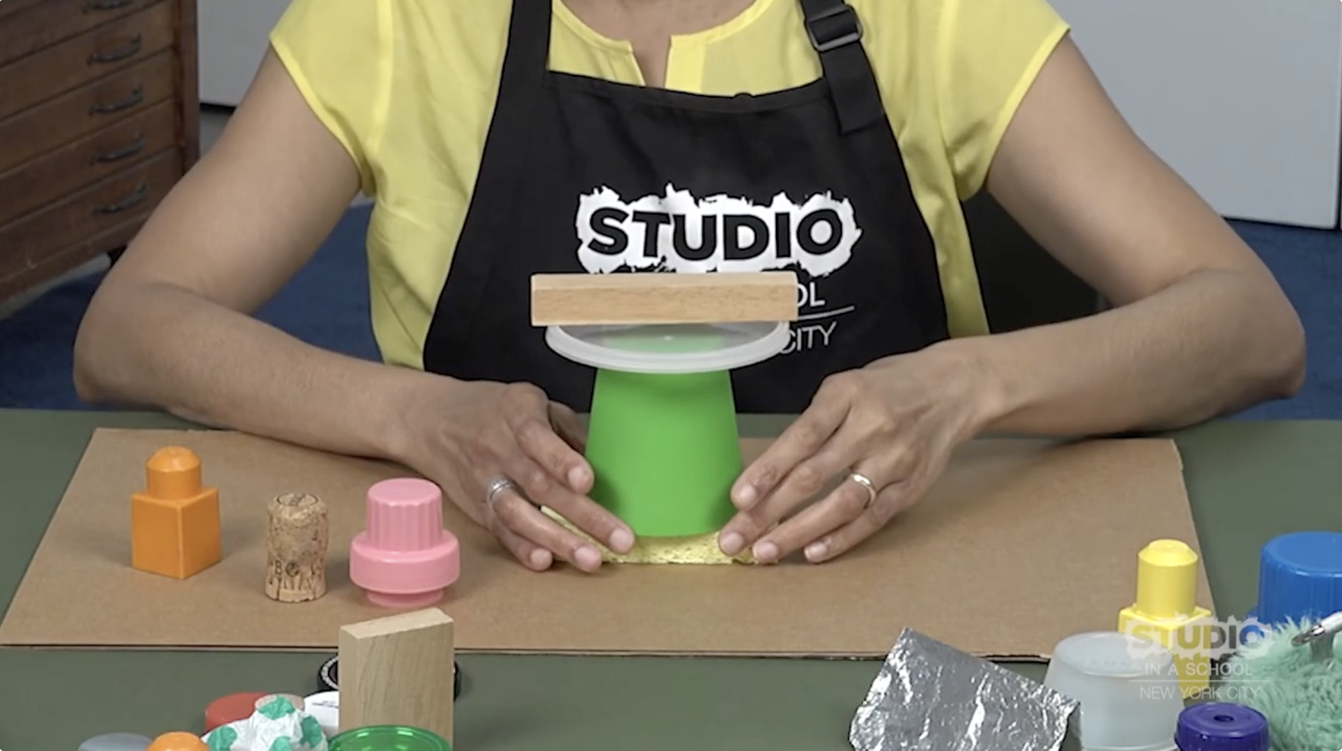 teacher stacking objects on top of cardboard